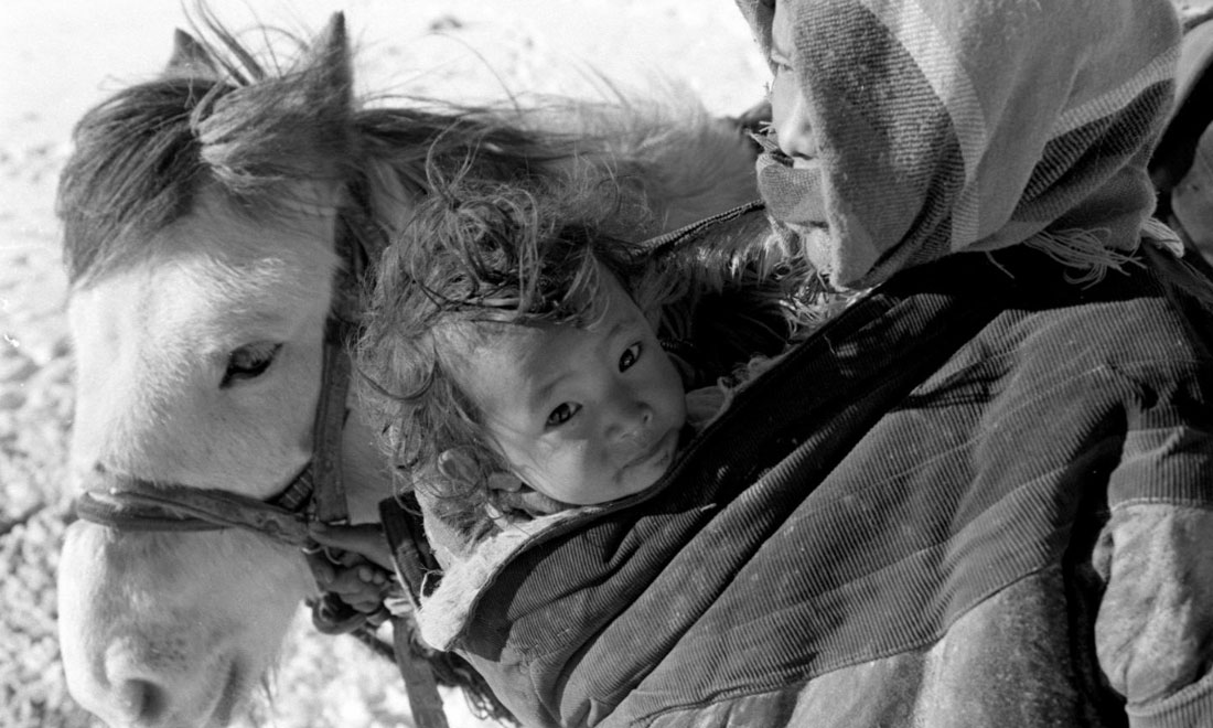 1990年3月，西藏當(dāng)雄縣納木湖鄉(xiāng)三村女牧民斯卓不畏嚴(yán)寒，懷抱幼子，準(zhǔn)備到遠(yuǎn)處放牧。新華社記者覺(jué)果攝